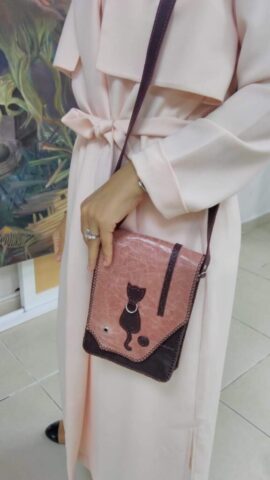 Katılımcımızın atölye eğitimimiz sırasında kendi tasarımıyla ürettiği bu çanta, hem teknik beceriyi hem de estetik zevki yansıtıyor. Pembe ve kahverengi deri kombinasyonu ile hazırlanan çanta, sevimli kedi figürüyle kişisel dokunuş kazanmış. El dikişi detayları, ürünün tamamen el emeğiyle üretildiğini vurgularken; özgün tasarımı da kullanıcısının tarzını ön plana çıkarıyor. Eğitim sürecinde katılımcıların yaratıcılıklarını ortaya koyabildikleri bu tür çalışmalar, onların becerilerini geliştirmelerine ve özgüven kazanmalarına büyük katkı sağlıyor.