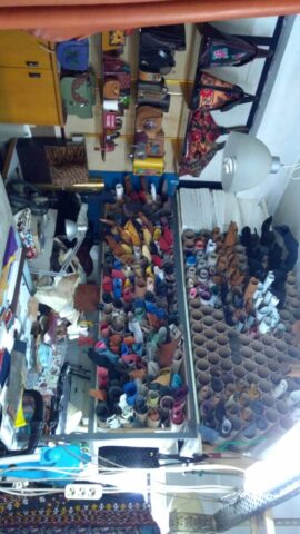 Raflarda düzenli şekilde sıralanmış renk renk deriler, üretim sürecinin çeşitliliğini ve zenginliğini yansıtıyor. Her biri farklı tasarımlar için seçilmiş bu deriler, atölyemizin el emeği ve sanatı bir araya getiren ruhunu ortaya koyuyor. Çalışma alanındaki düzen, ustalıkla yürütülen üretim sürecinin titizliğini de gözler önüne seriyor.