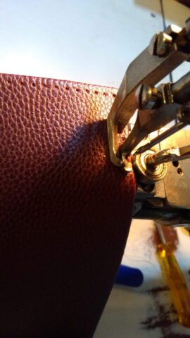 Endüstriyel dikiş makinesinde uygulanan hassas bir dikiş işlemi görülüyor. Deri yüzey üzerindeki ince dikiş izleri, el işçiliğinin özenini ve kullanılan ekipmanın profesyonelliğini yansıtıyor. Bu aşama, ürünün hem dayanıklılığı hem de estetik bütünlüğü açısından büyük önem taşıyor. Deri yüzeyin düzgünlüğü ve dikişin hatasız ilerleyişi, işin ustalıkla yapıldığını gösteriyor.