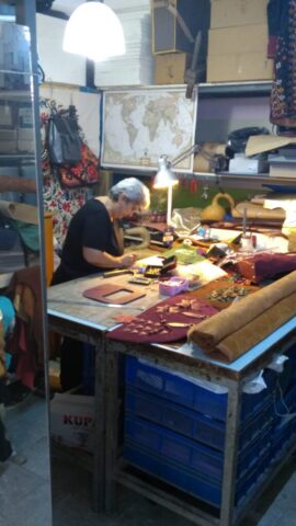 Atölyemizde geçen her an, öğrenmenin ve üretmenin heyecanını barındırır. Bu karede, eğitim sürecinde birebir uygulamalı çalışma yapan bir kursiyerimizi görüyorsunuz. Deri parçaları tek tek işlenirken, her detay sabırla ve ustalıkla ortaya çıkıyor. Sessizlik içinde akan zaman, el sanatlarının derinliğini ve öğretici gücünü gözler önüne seriyor.