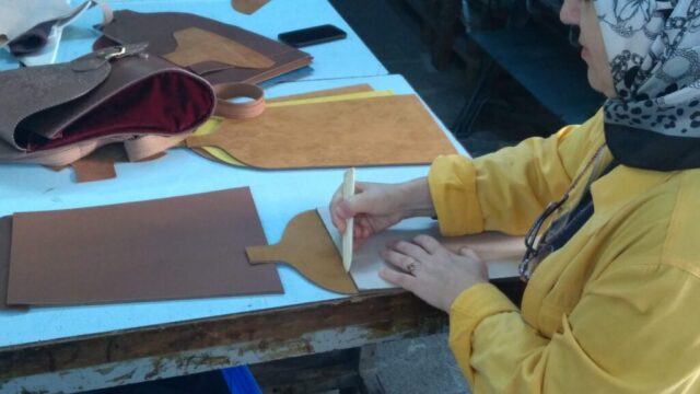 Her el yapımı çanta, bir taslakla başlar. Görselde, katılımcımız deri parçaları büyük bir özenle işaretliyor. Bu aşama, ürünün şeklinin ve dengesinin temelini oluşturur. El becerisi, sabır ve hassasiyet bu sürecin ayrılmaz parçalarıdır.
