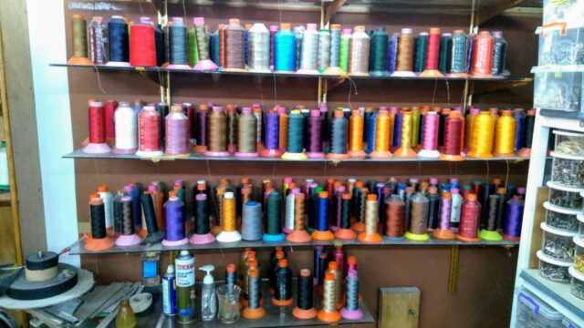 Deri atölyemizin en renkli köşelerinden biri: iplik raflarımız. Her biri farklı projeler için seçilmiş bu iplikler, sadece dikiş değil, aynı zamanda tasarımın bir parçasıdır. Renk uyumu, dayanıklılık ve kalite gibi detaylar; ürünün hem estetik hem de işlevsel başarısında belirleyici rol oynar.